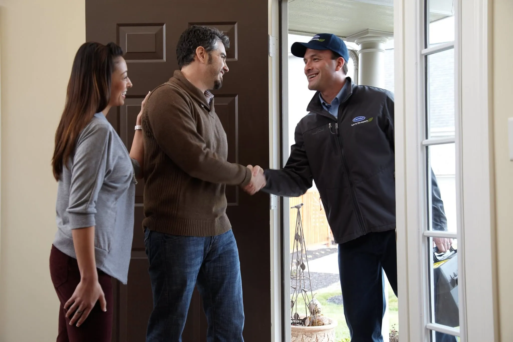A Snazzy technician shaking hands with a homeowner at the front door