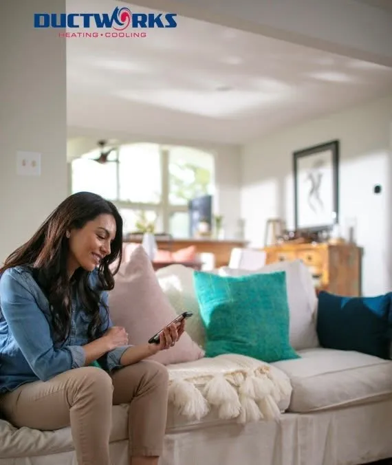 A homeowner relaxing on a couch at home, checking a phone