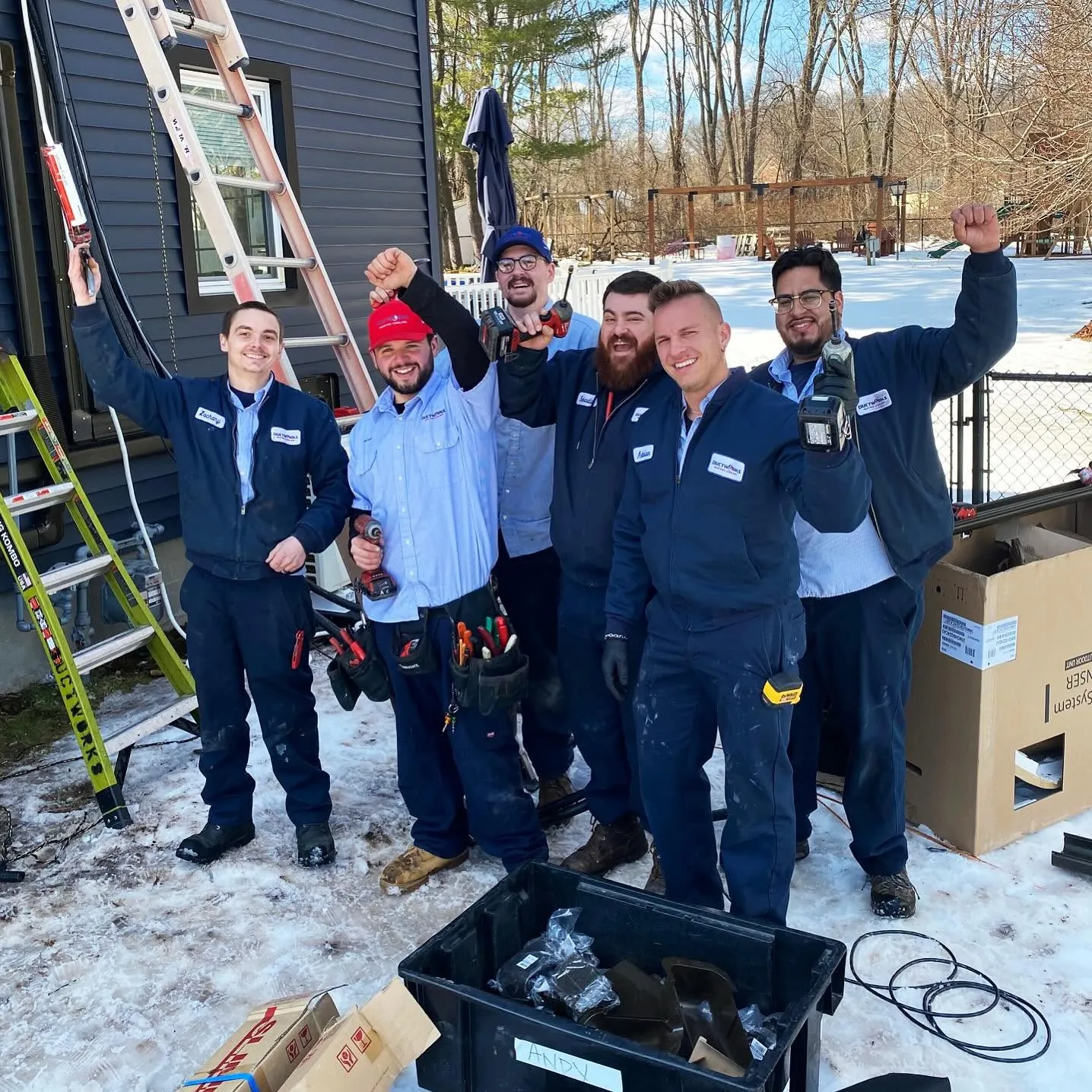 The Snazzy crew together outside a house in the snow