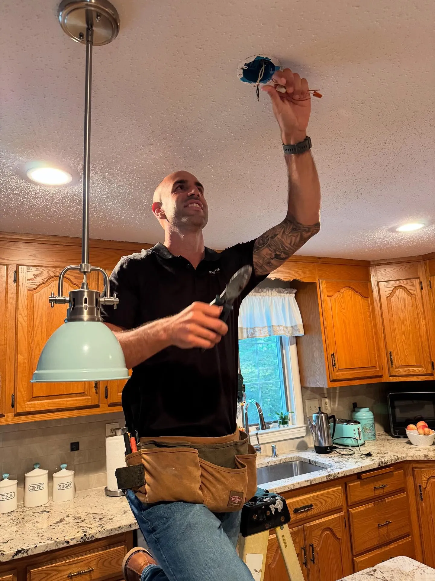 A Snazzy electrician installing a ceiling light fixture